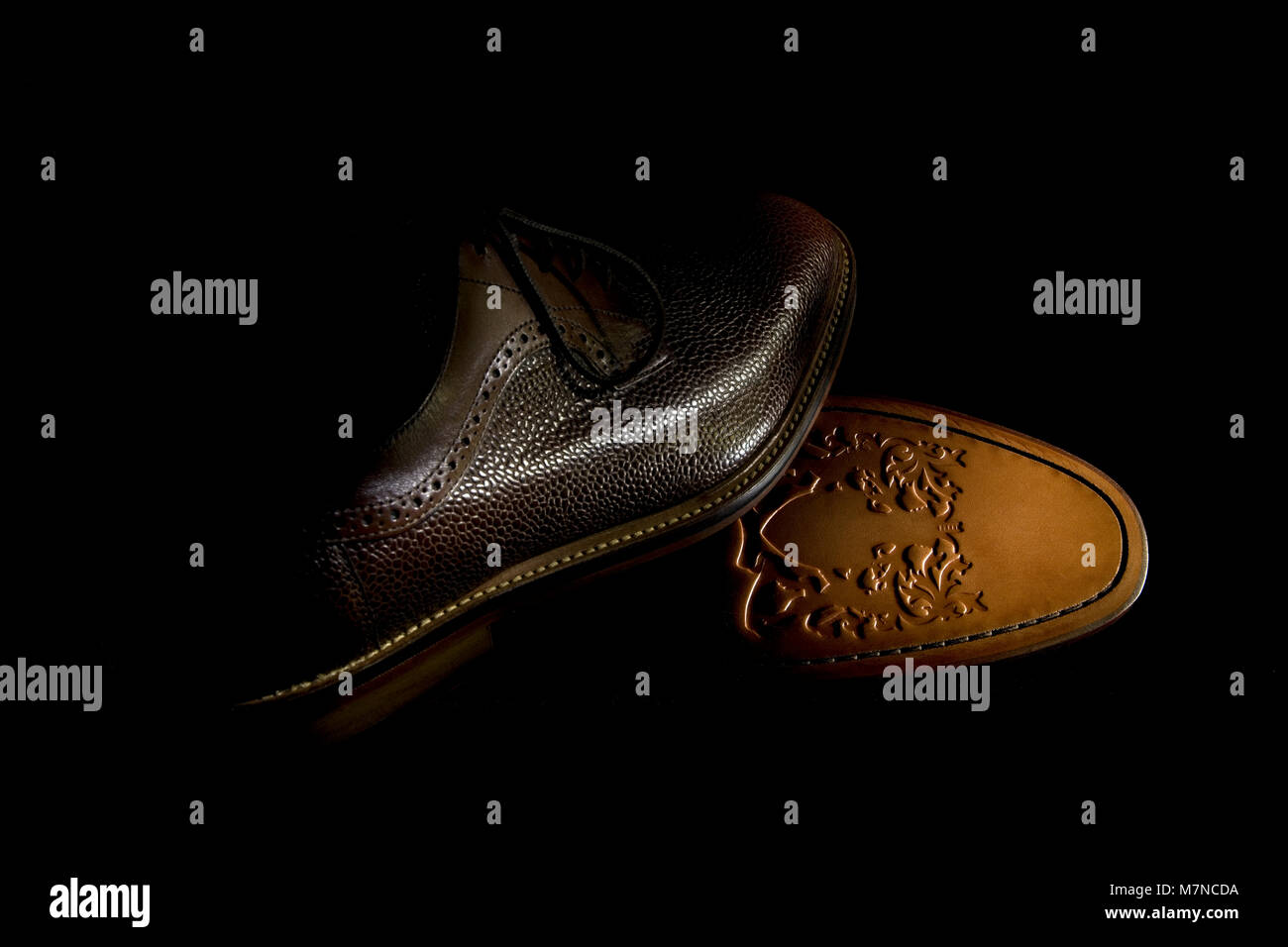 Ein paar Brown's Herrenschuhe mit geprägtem Leder Sohle mit Low Key  Beleuchtung gegen einen dunklen Hintergrund Stockfotografie - Alamy