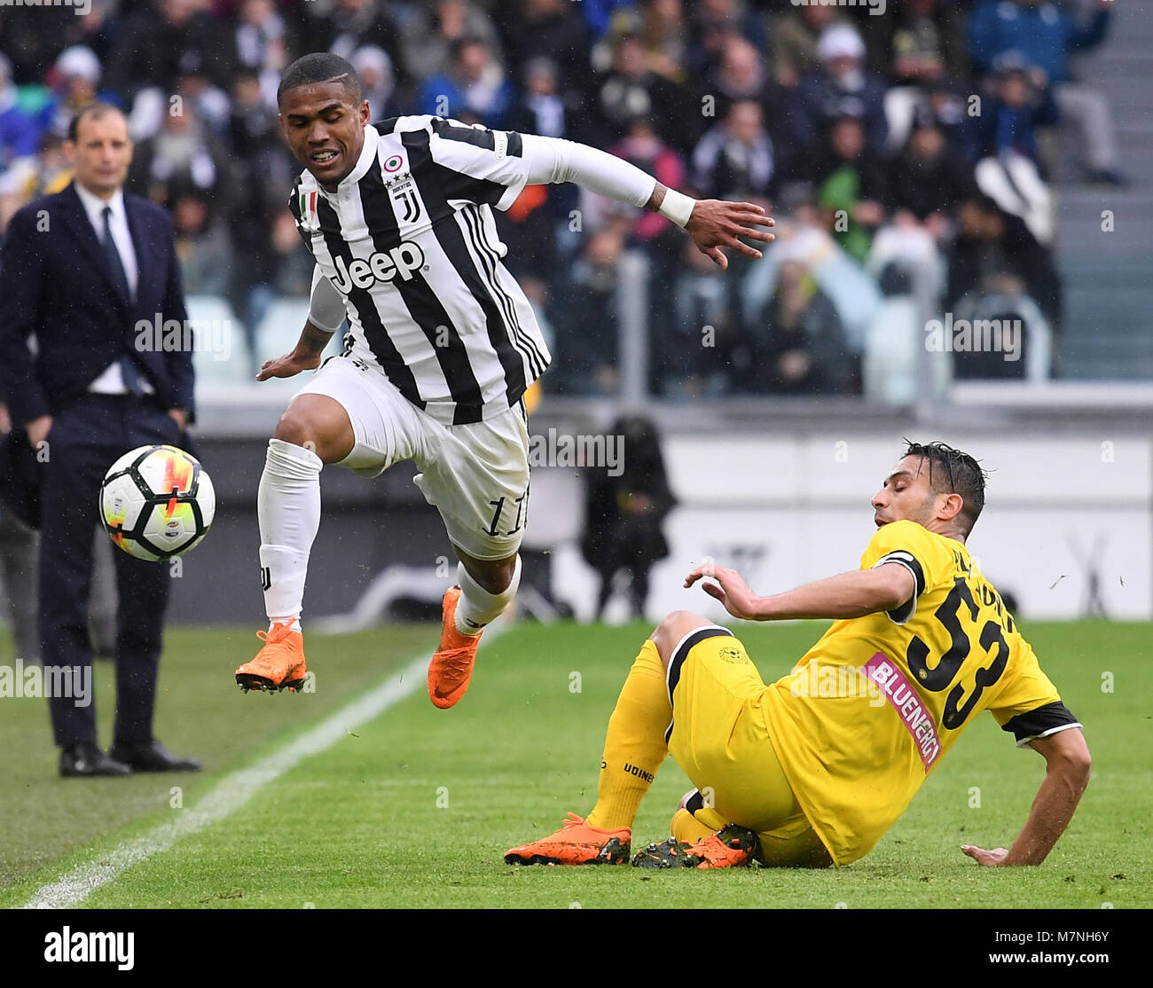 Turin, Italien. 11 Mär, 2018. Juventus' Douglas Costa (L) Mias mit Udinese der Kadhim Ali Adnan während einer Serie ein Fußballspiel zwischen Juventus Turin und Udinese in Turin, Italien, 11. März 2018. Juventus Turin gewann 2-0. Credit: Alberto Lingria/Xinhua/Alamy leben Nachrichten Stockfoto