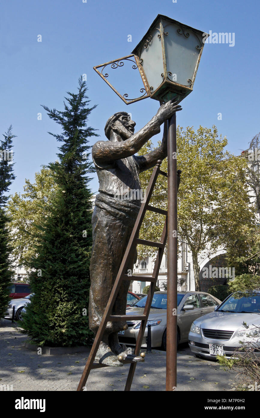 Bronze Skulptur von einem Mann, der auf einer Leiter eine Straßenlaterne, Tiflis, Georgien zu Licht Stockfoto