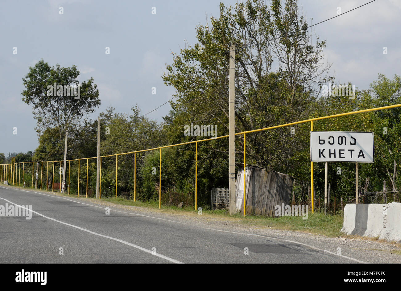 Oberirdische Erdgasleitungen, gelb lackiert und während der sowjetischen Zeit installiert, führen neben einer Straße durch Kheta, Georgien Stockfoto