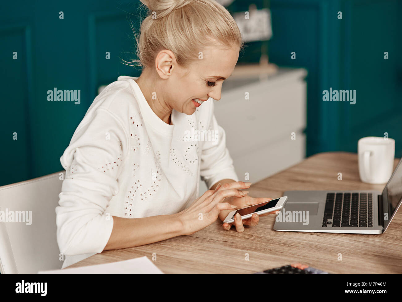 Fröhliche Frau Lesen von Text Meldung im Heimbüro Stockfoto