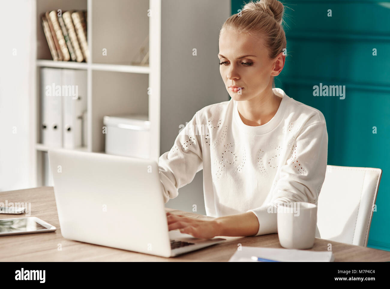 Schwere Frau mit Laptop zu Hause arbeiten im Büro Stockfoto