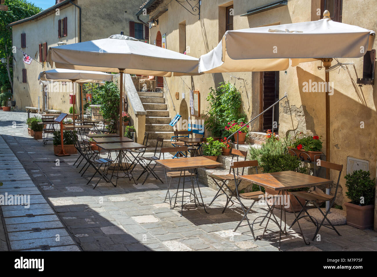 Cafe Tische und Stühle in einer Straße in der Ortschaft Bagno Vignoni, Toskana, Italien Stockfoto