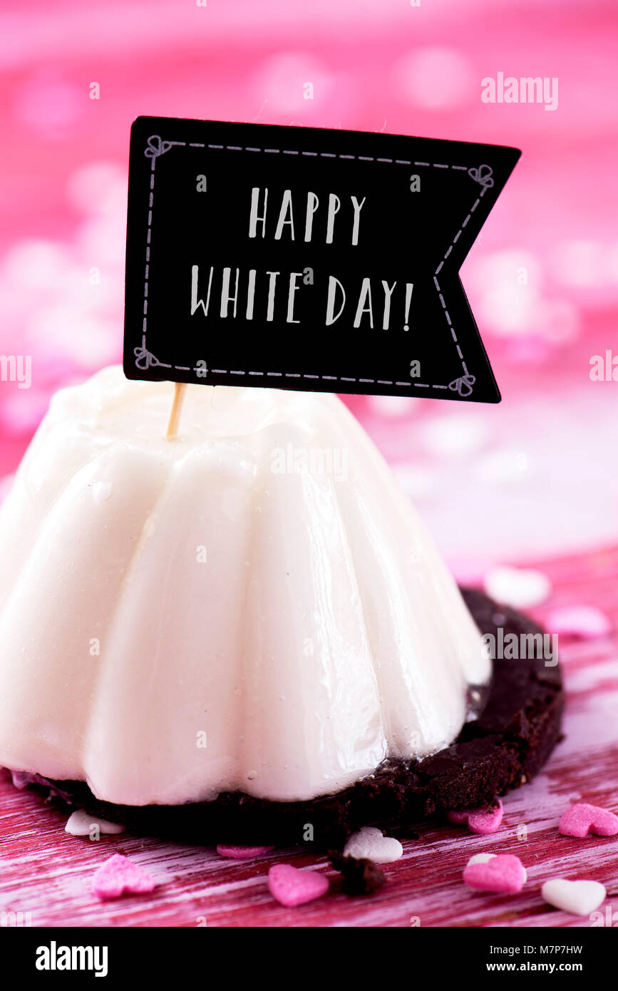 Eine weiße Kuchen gekrönt mit einem Flag-förmiges Schild mit dem Text happy White Day geschrieben, die beliebte asiatische Festlichkeit durch Frauen beobachtet, die Stockfoto