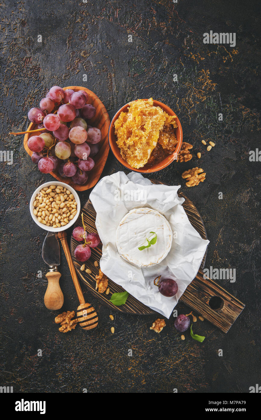 Camembert Käse mit Trauben, Honig in den Waben mit Zedern- und Walnüsse und Mandeln. Ansicht von oben mit der Kopie. Stockfoto