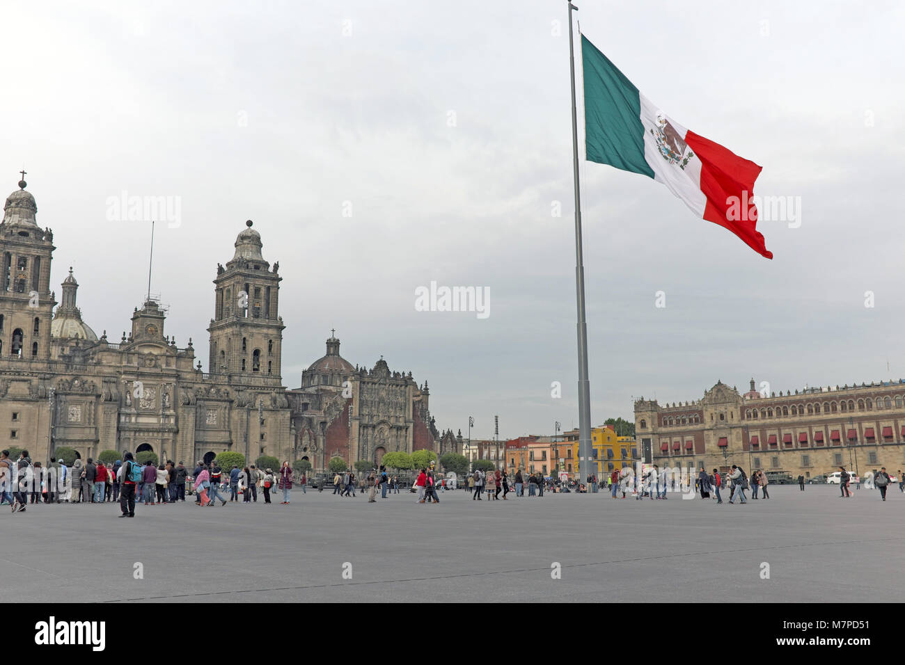 Die Nationalflagge von Mexiko Wellen über dem zocalo in Mexico City, einer der größten öffentlichen Plätze der Welt, umgeben von historischer Architektur. Stockfoto