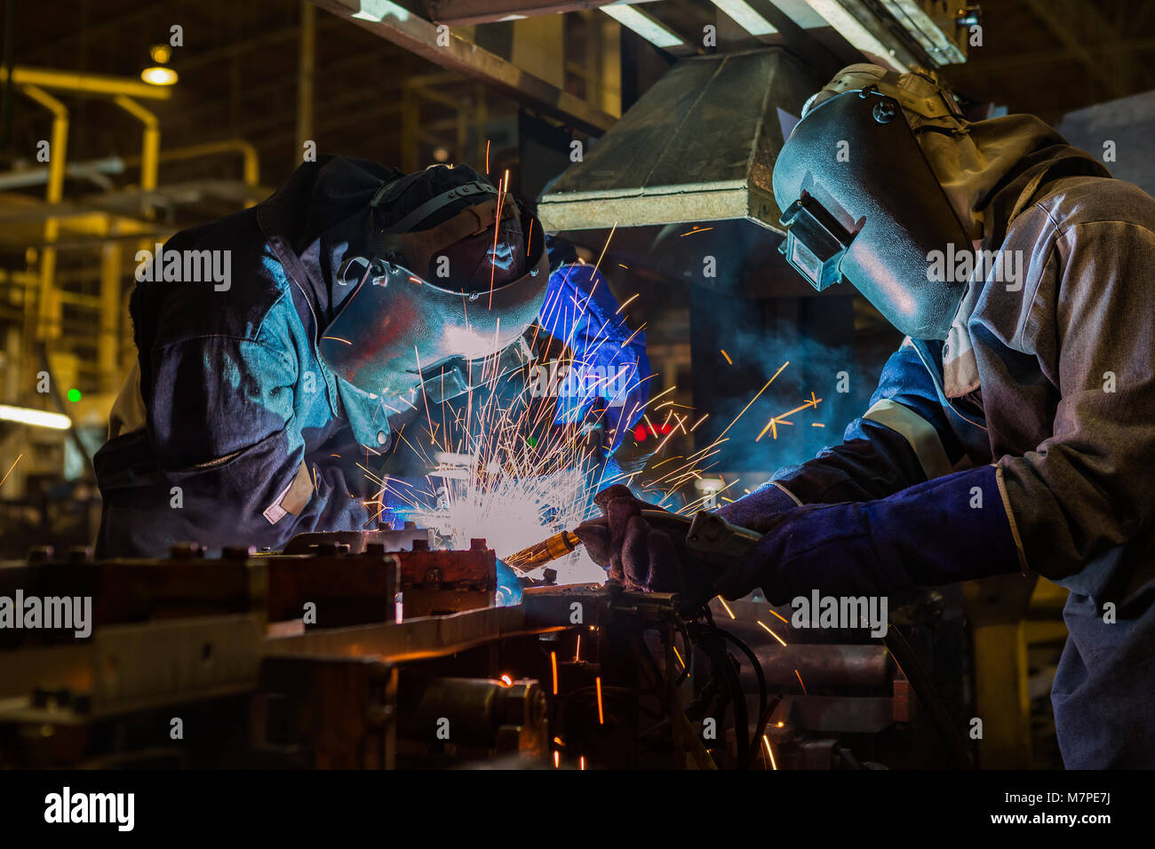 Team Arbeiter schweißen Teil im Werk Stockfoto