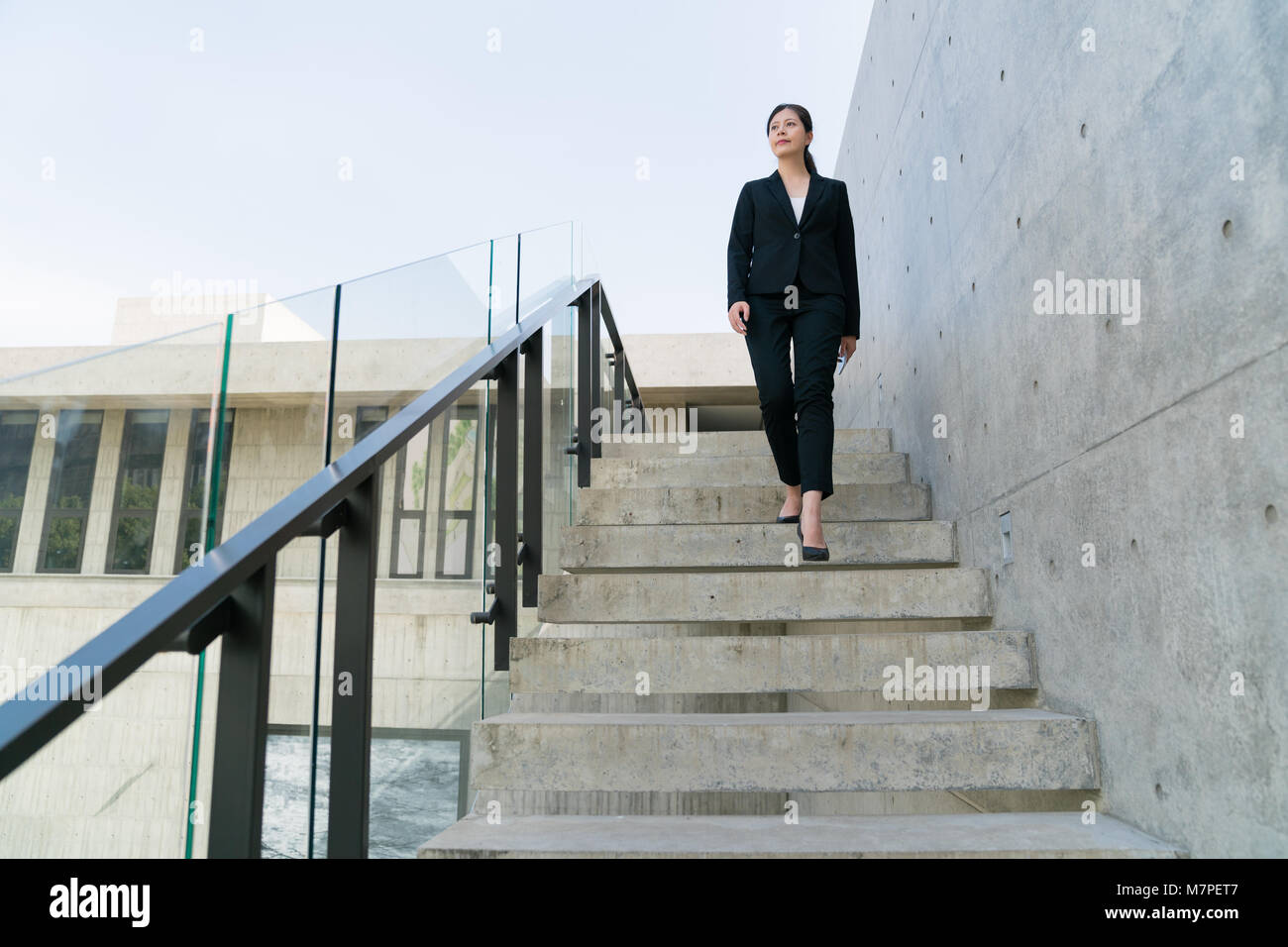 Zuversichtlich erfolgreiche Geschäftsfrau hinunter Treppe t in eine ruhige und entspannte Art und Weise. Stockfoto