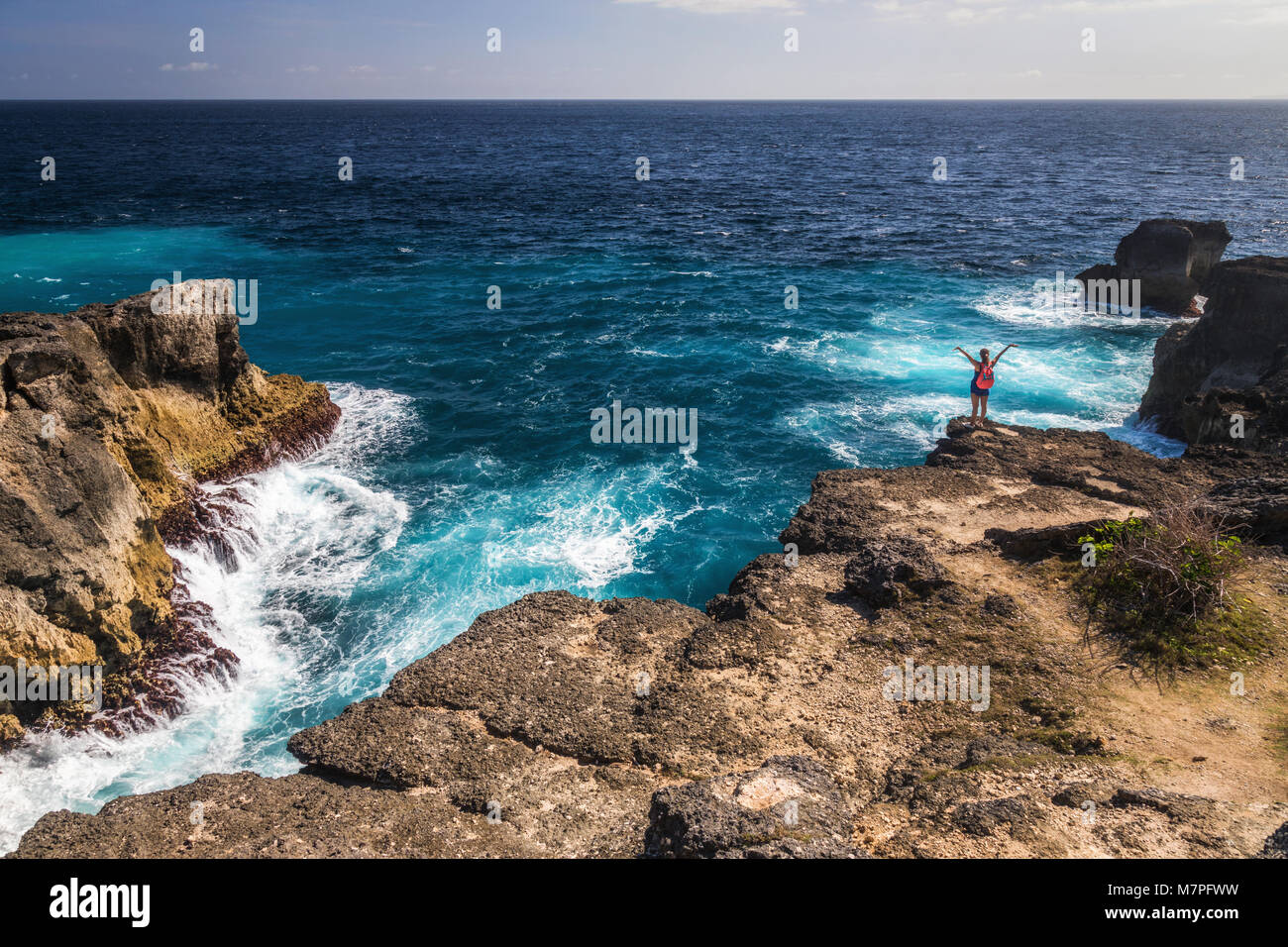 Steht an der Spitze einer riesigen Klippe am Rande des Indonesischen Ozean mit klarem, blauem Wasser, das Ufer Stockfoto