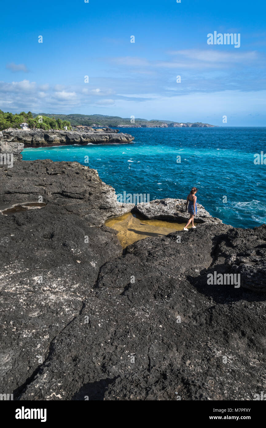 Steht an der Spitze einer riesigen Klippe am Rande des Indonesischen Ozean mit klarem, blauem Wasser, das Ufer Stockfoto