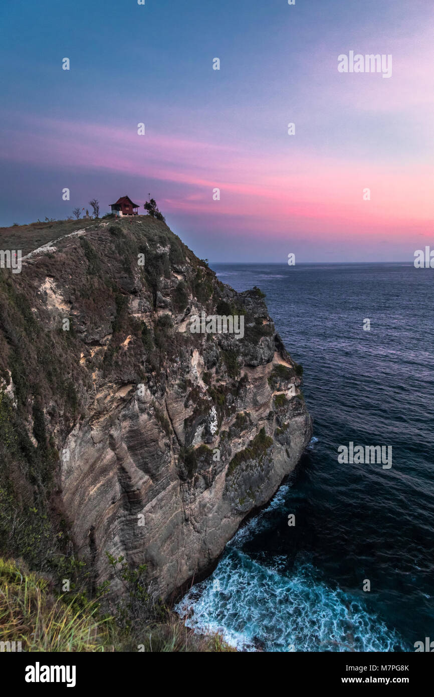 Rosa Sonnenuntergang am Atuh Beach auf Nusa Penida Insel in Indonesien mit einem einsamen Klippe Haus Stockfoto