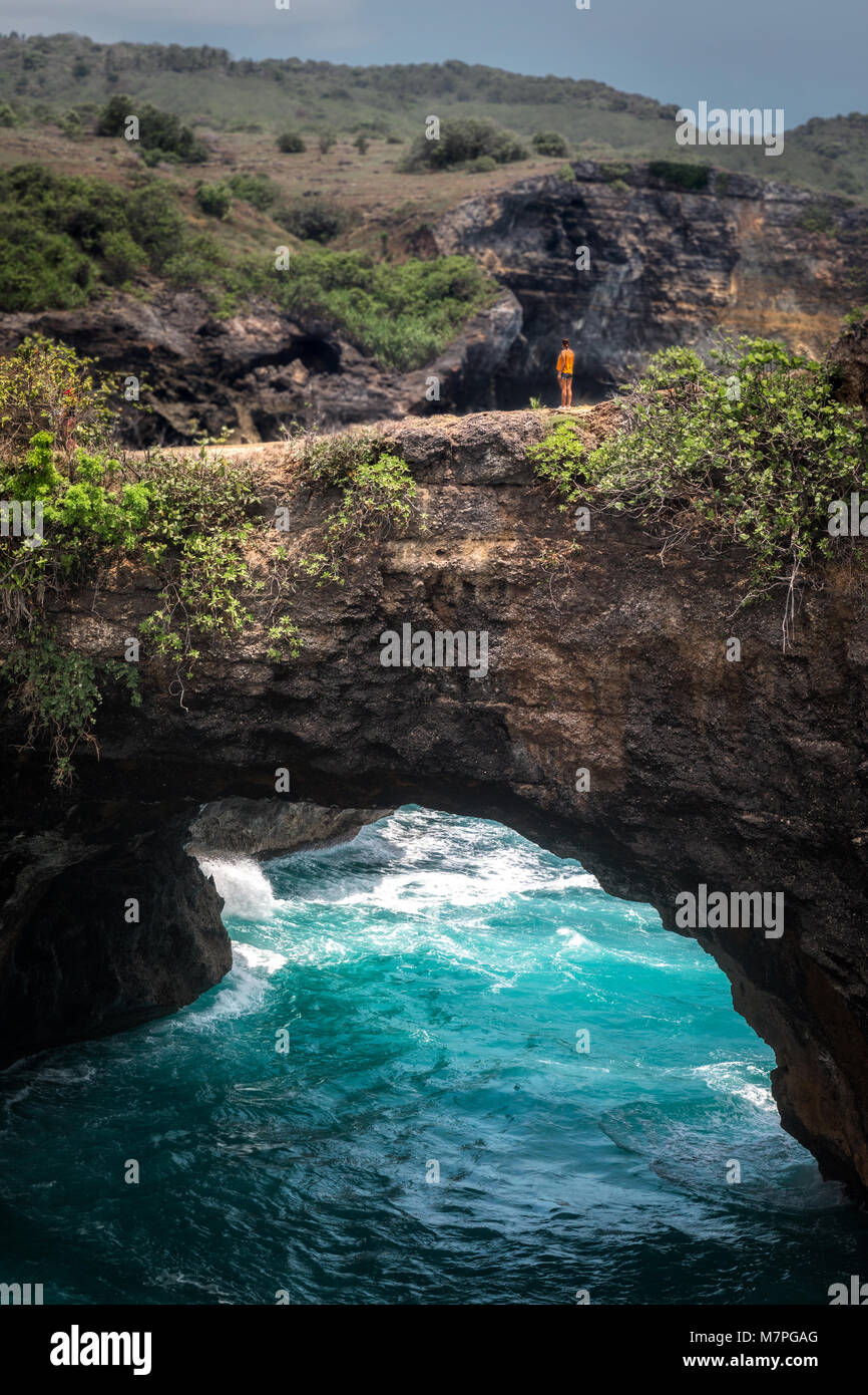 Kleine menschliche stehend an einem weit entfernten Abstand oben auf dem riesigen broken Cliff zeigt die Skala in perfekter Form Stockfoto