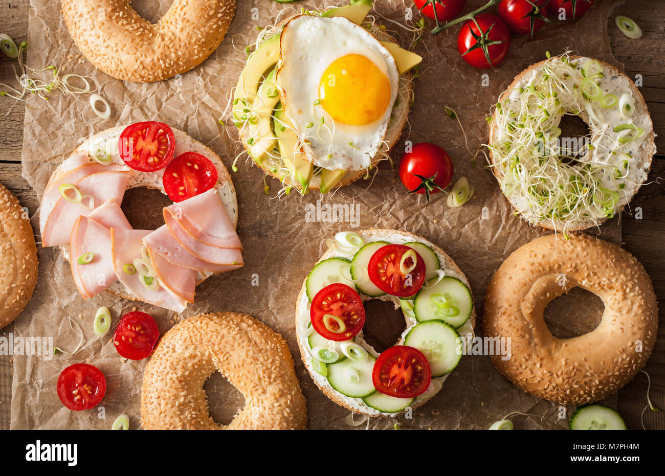 Auswahl an Sandwiches auf Bagels: Ei, Avocado, Schinken, Tomate, Weichkäse, Alfalfa Sprossen Stockfoto