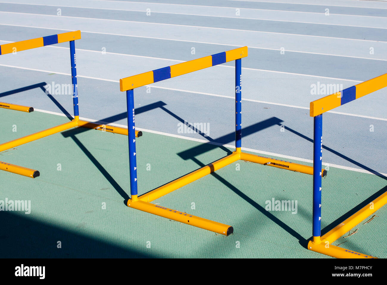 Gelb Blau springen Hürden auf Running Tracks mit schönen Schatten Stockfoto