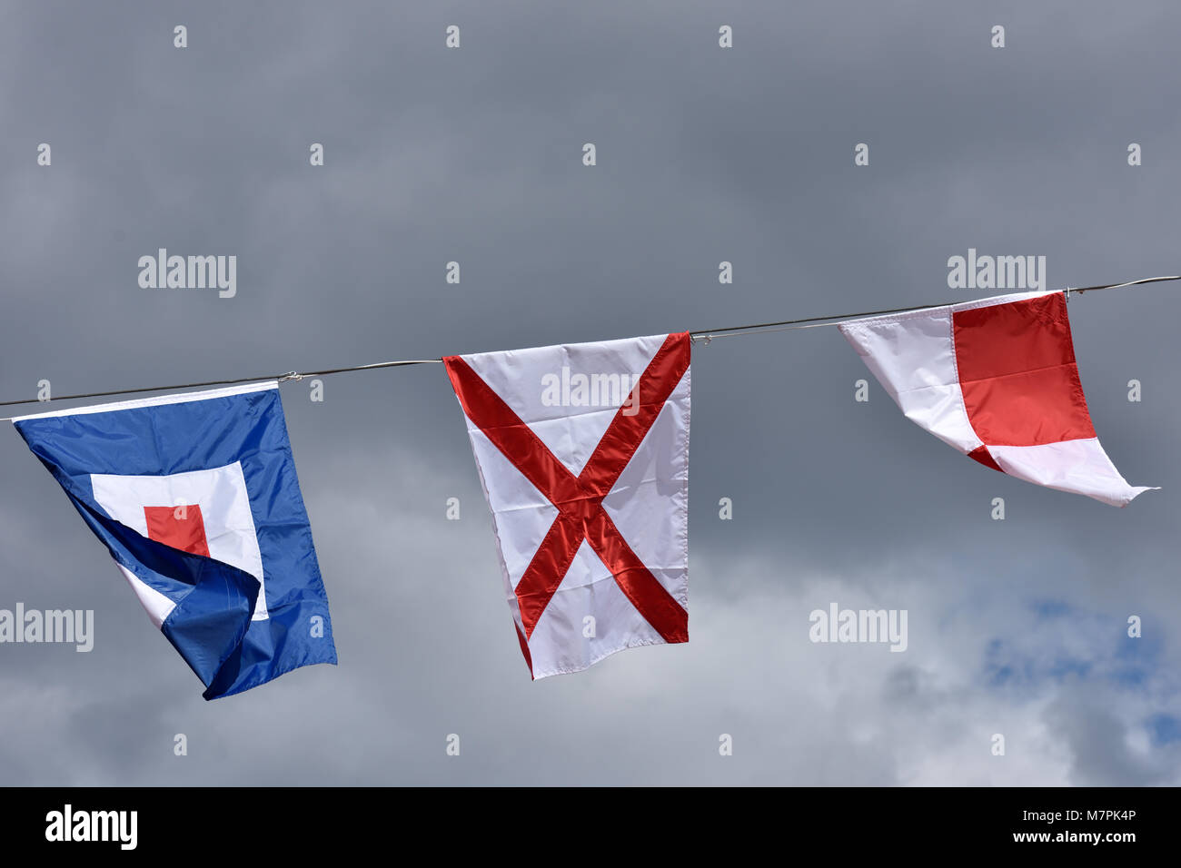 International Maritime Signal flags Einheitliche, Victor, und Whiskey gegen bewölkter Himmel Stockfoto