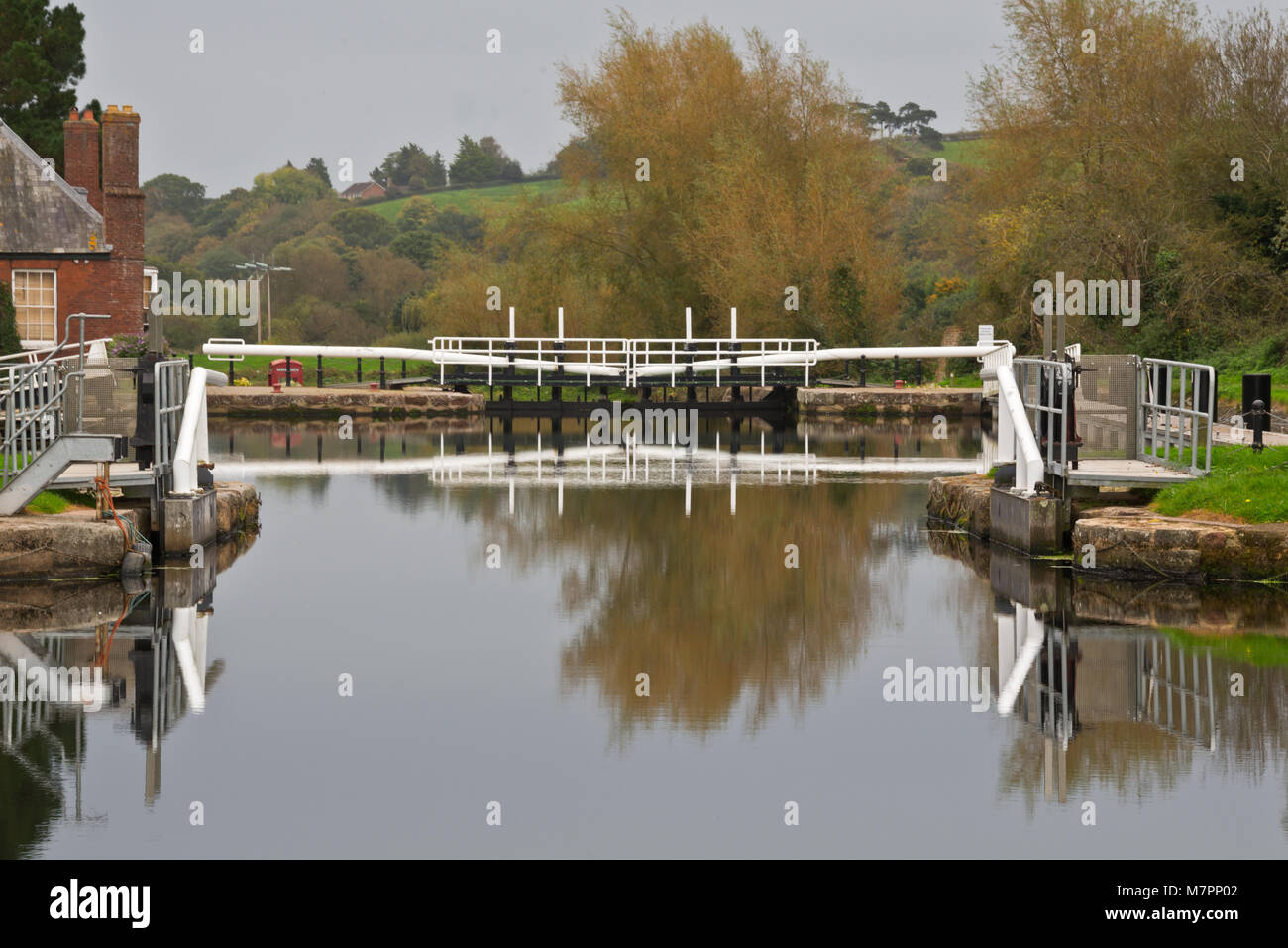 Reflexionen der Schleusentore an Schlössern auf der Exeter Kanal auf einem noch Herbst Tag. Teil der Exe Tal. Stockfoto