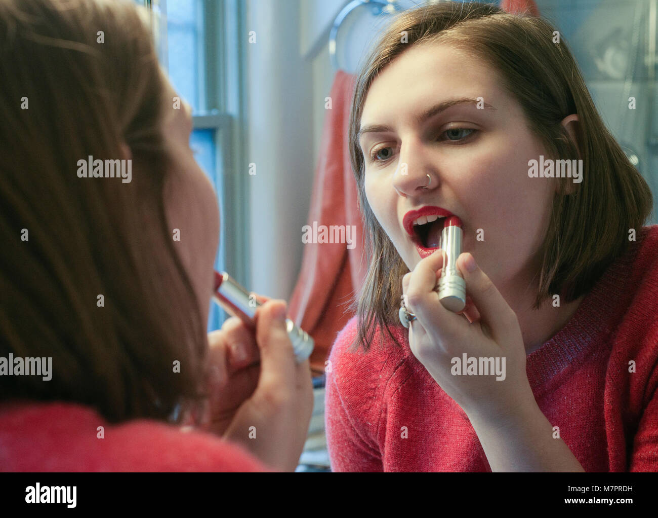 Ein Mädchen im Teenageralter setzen auf Lippenstift. Stockfoto