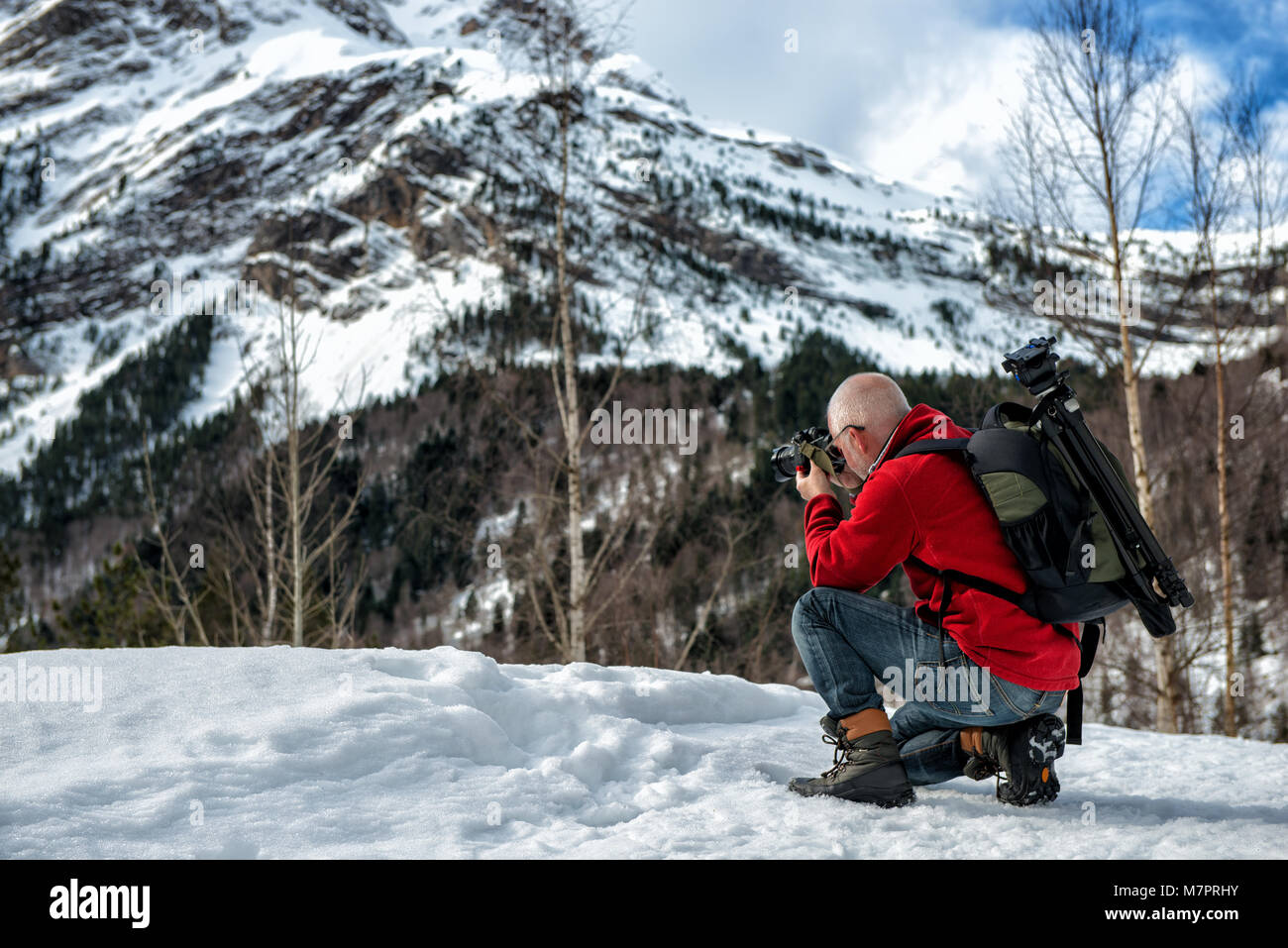 Mann Fotograf ein Bild in die verschneiten Berge nehmen Stockfoto