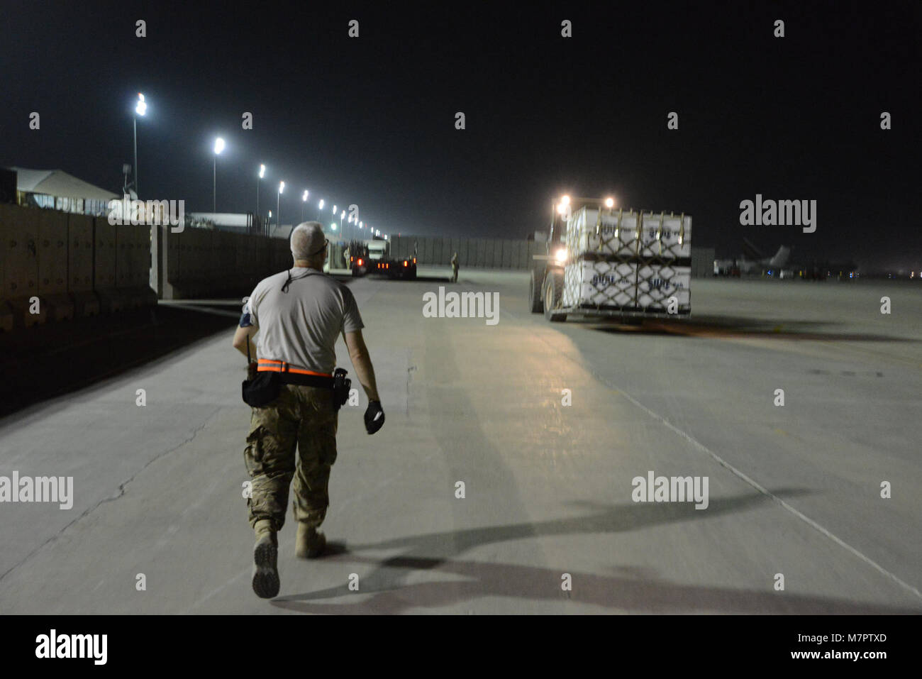 Flughafen Bagram, Afghanistan - Senior Master Sgt. Steven Mooney, die derzeit mit dem 455Th Expeditionary Antenne Anschluss Squadron, Flughafen Bagram, Afghanistan folgt ein Gabelstaplerfahrer, der Flug Linie in Vorbereitung der Beladen auf einen K-Loader zum 14. Juni 2014. Mooney und andere Flieger zu 455 EAPS zugeordnet mehr als 101,054 Pfund von Tiefkühlkost für Forward Operating Base Jalabad, Afghanistan bestimmt palettiert. Sie arbeitete in einem schnellen Tempo mit Fremdfirmen, um die Lebensmittel verpackt und auf eine C-130J Super Hercules geladen von Dyess Air Force Base, Texas eingesetzt. Die verderbliche Waren Stockfoto