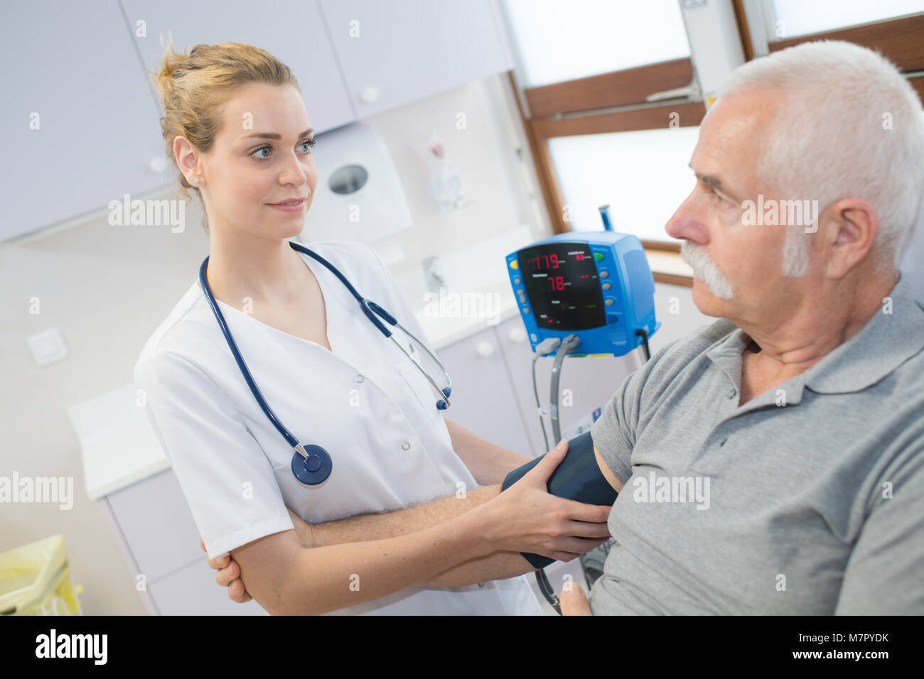 Ärztin prüfen alte Mann Patienten arterieller Blutdruck Stockfoto