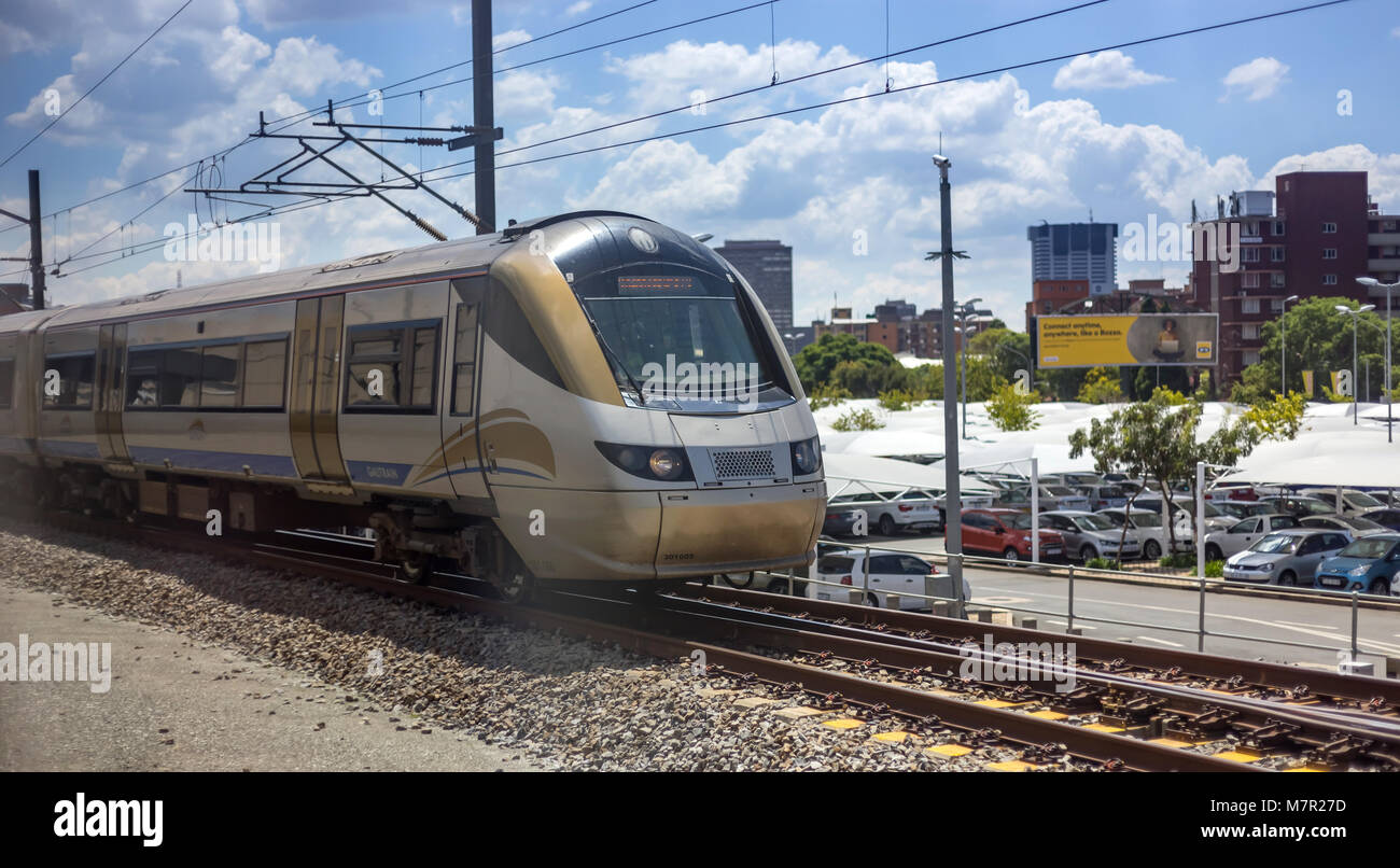 Johannesburg, Südafrika - 8. März 2018: Zug auf Schienen mit der Stadt im Hintergrund. Stockfoto