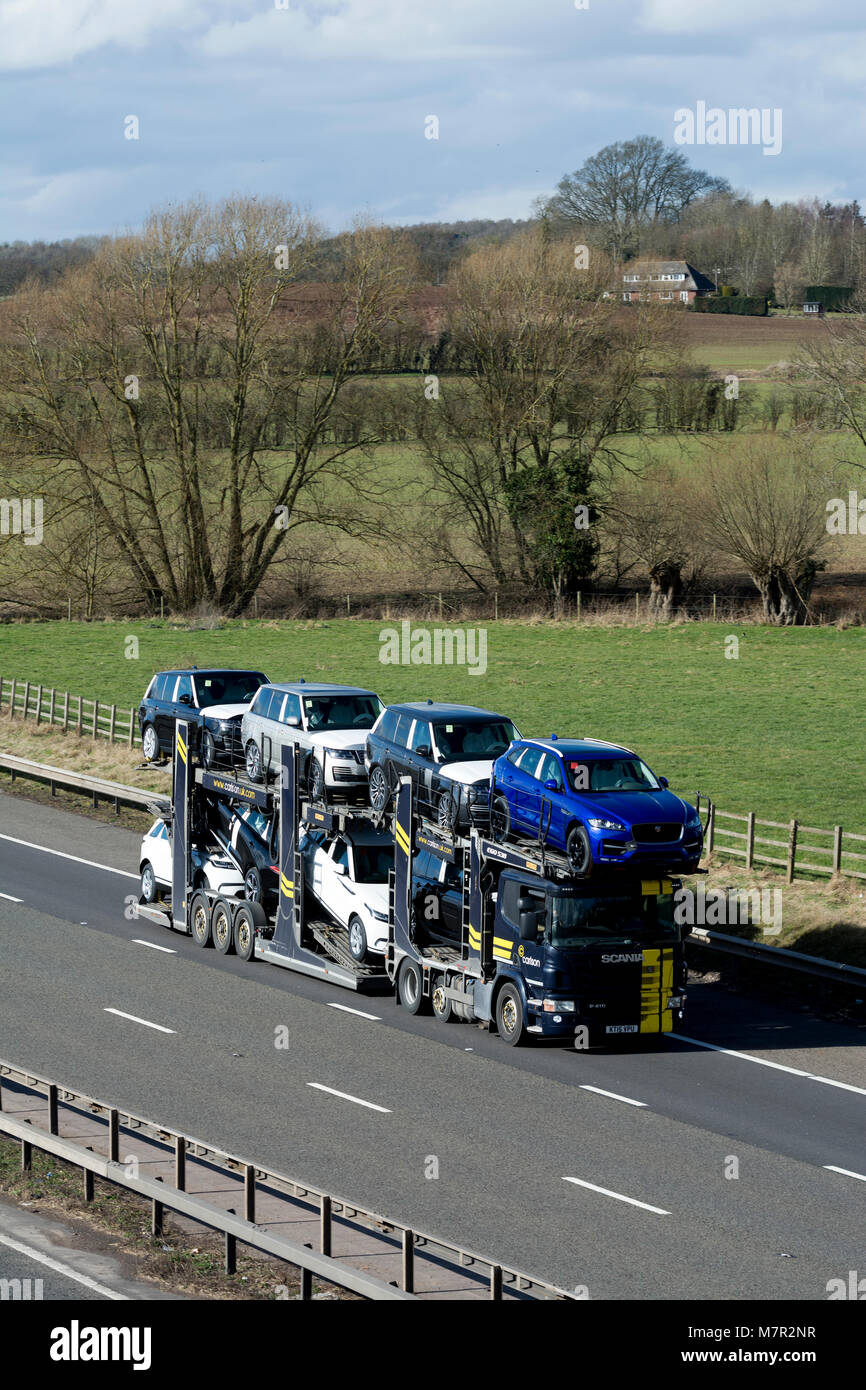 Neue Jaguar und Land Rover Autos auf einem Transporter auf der Autobahn M40, Warwickshire, Großbritannien Stockfoto