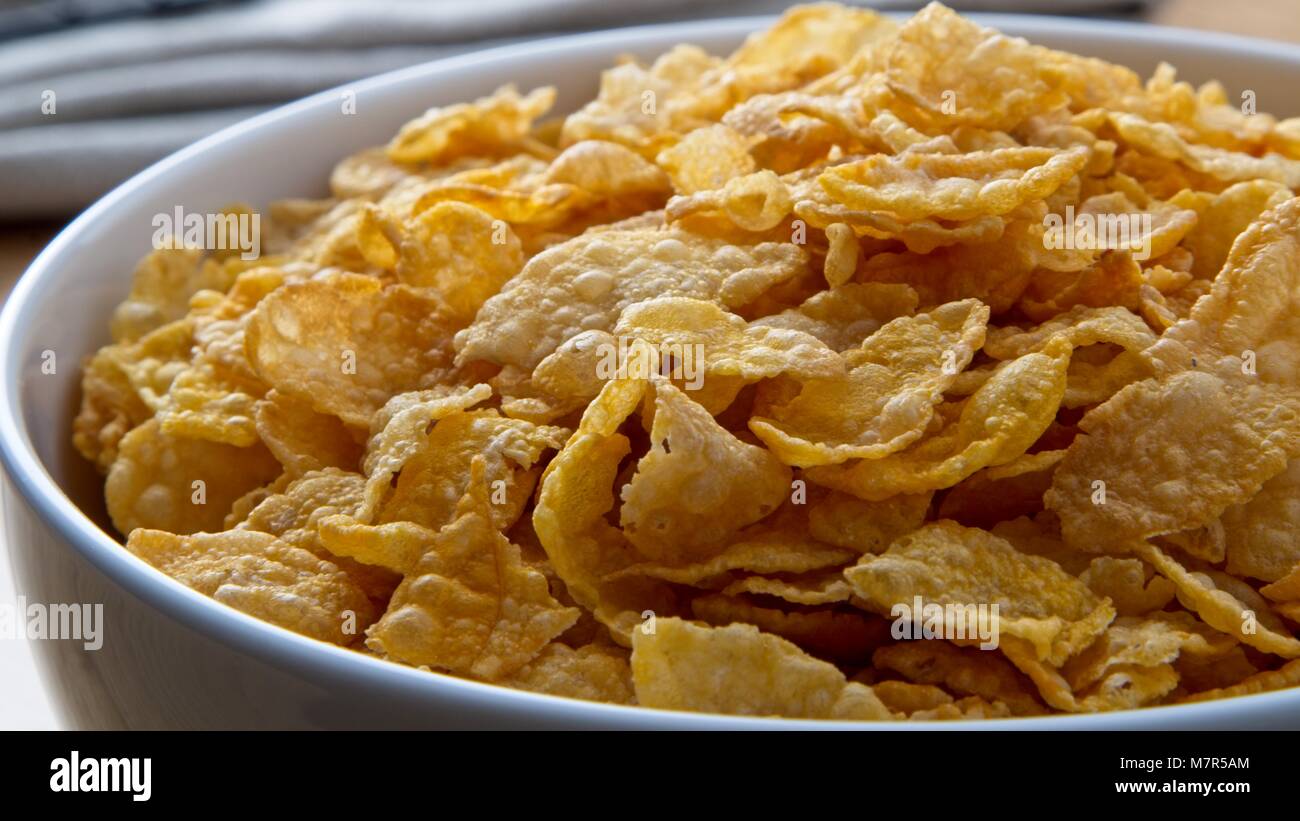 Schüssel Cornflakes in Weiß Schüssel auf Eiche Oberfläche Nahaufnahme Stockfoto