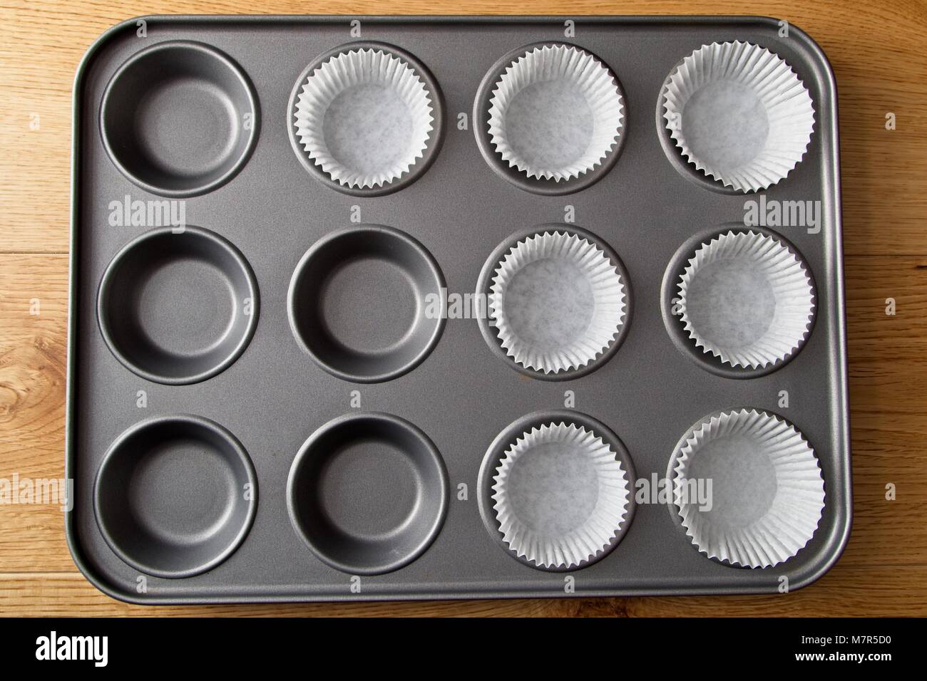 Backform für Cup Cakes und Kuchen Teil mit Papier Fällen gefüllt Stockfoto