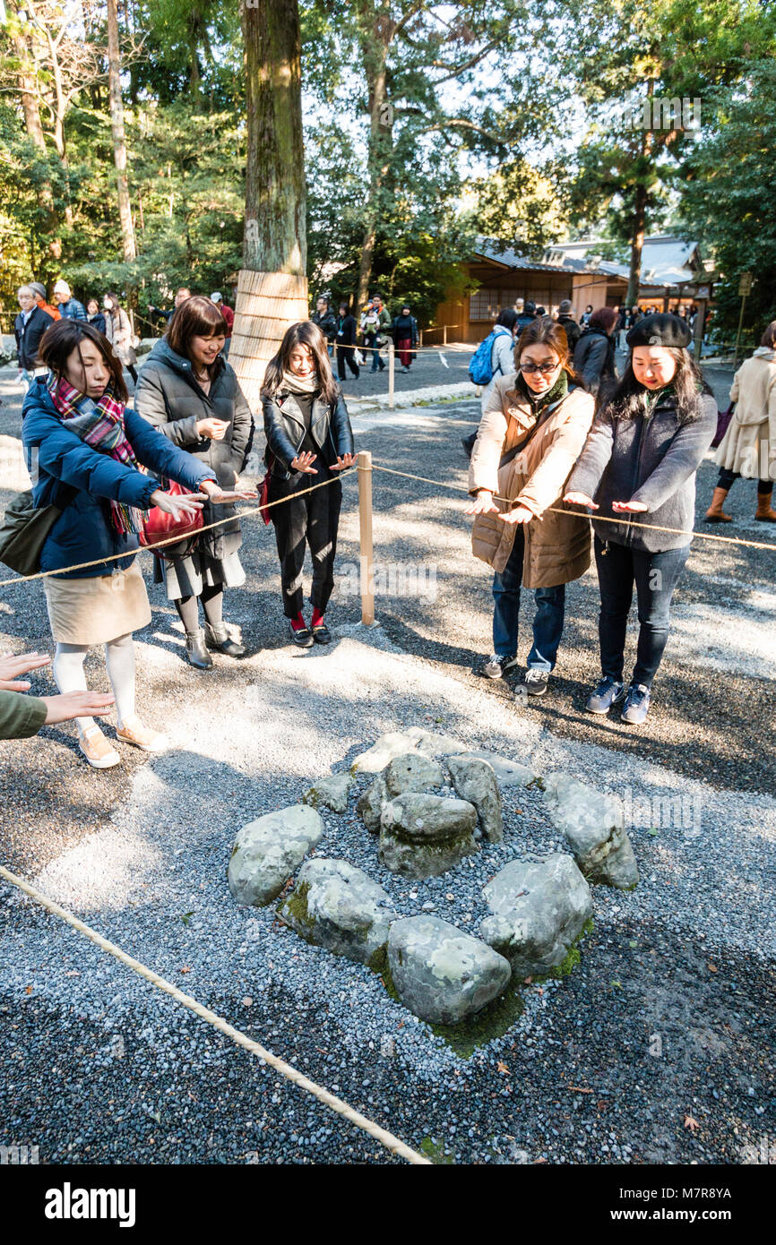 Japan, Ise, Ise-jingu Geku, äußere Schrein. Menschen lernen über das Seil mit ausgestreckten Händen positive Energie zu bekommen, Kami, aus Angst rock. Stockfoto