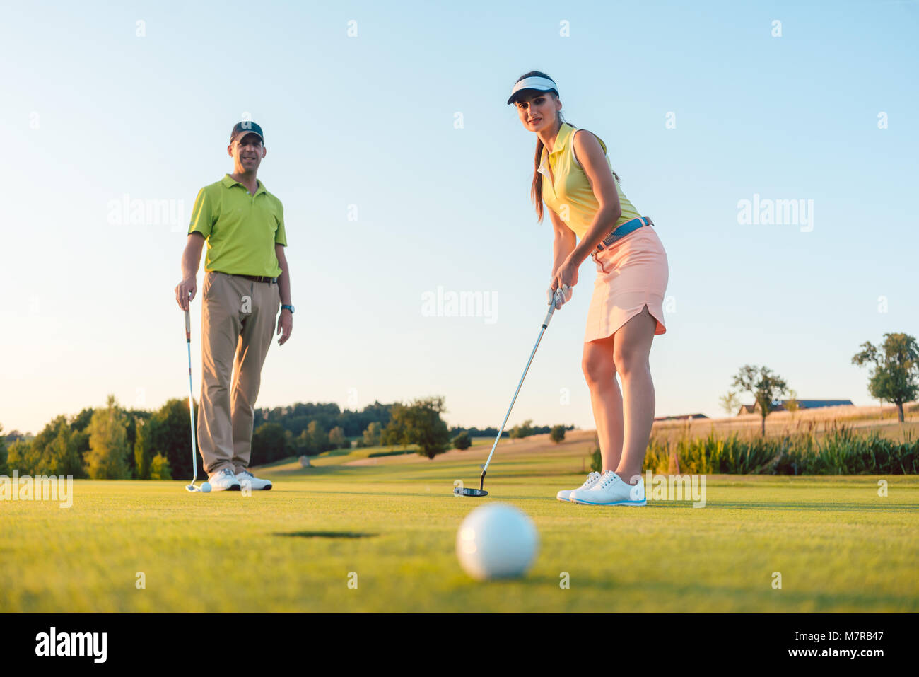 Wettbewerbsfähige Frau am Golf ball Suchen mit Enttäuschung Stockfoto