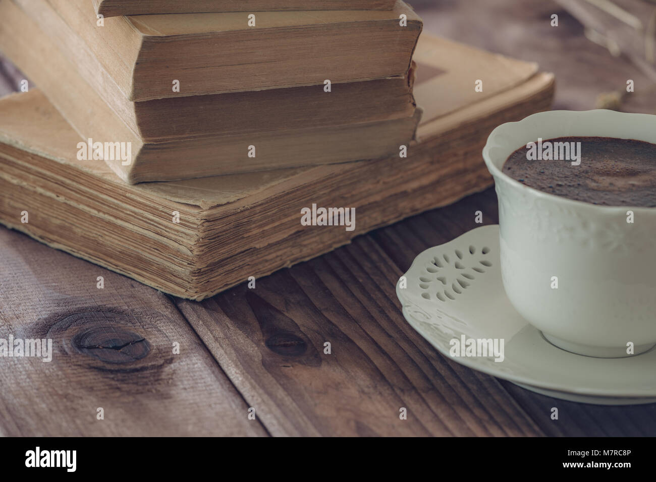 Alte Bücher zusammen mit einer Tasse Kaffee. Stockfoto