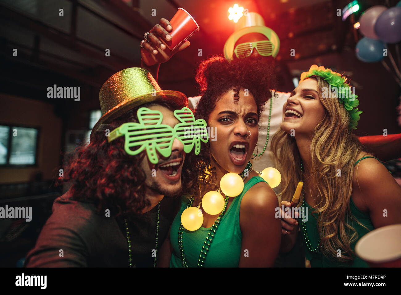 Gruppe von jungen Freunden feiern St. Patrick's Day an der Bar. Menschen Spaß an der Bar. Stockfoto