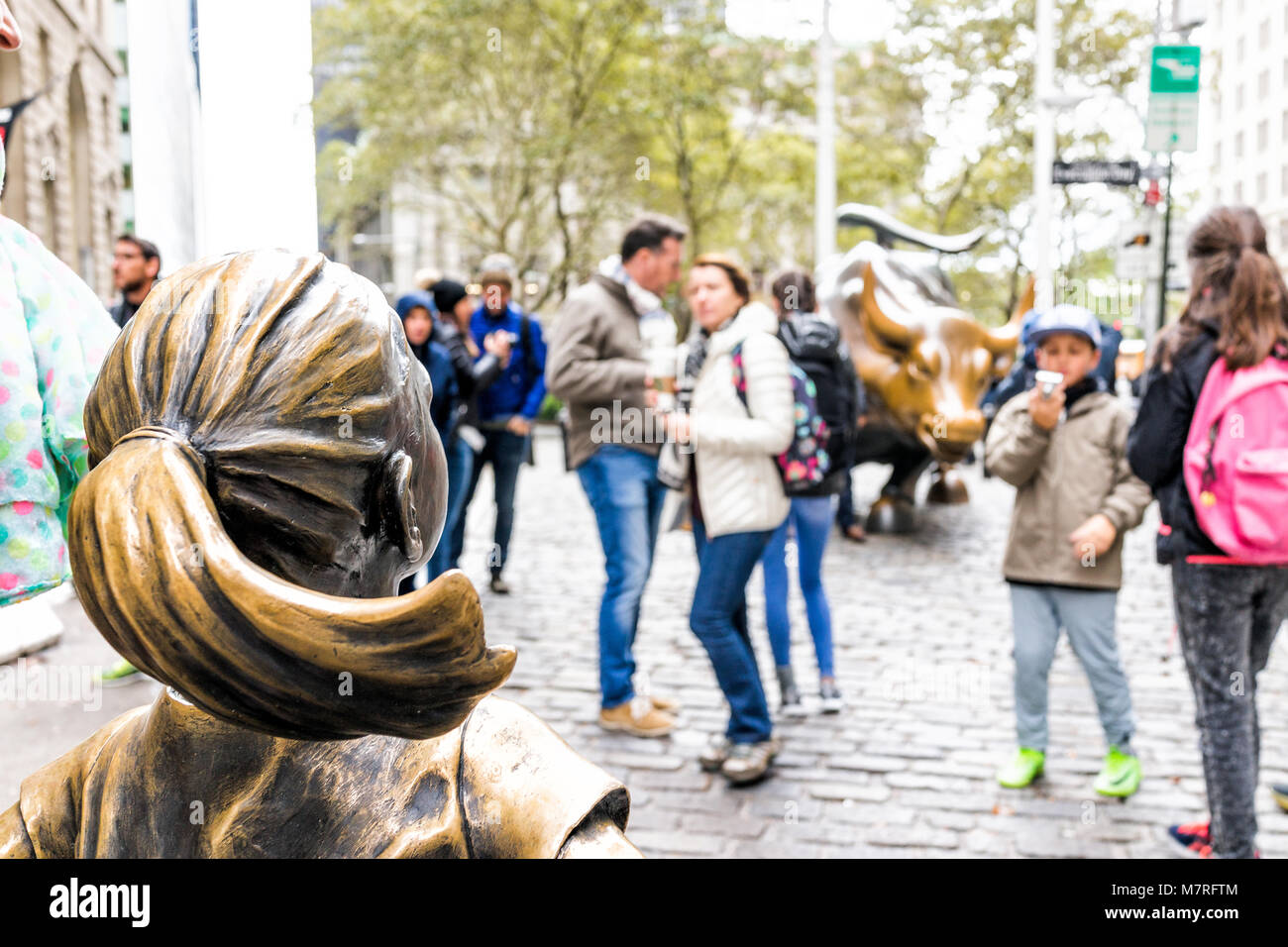 New York City, USA - 30. Oktober 2017: Wall Street Börse Der Furchtlose Mädchen Statue vor wütenden Stier Metall in NYC Manhattan geringere finanzielle Stockfoto