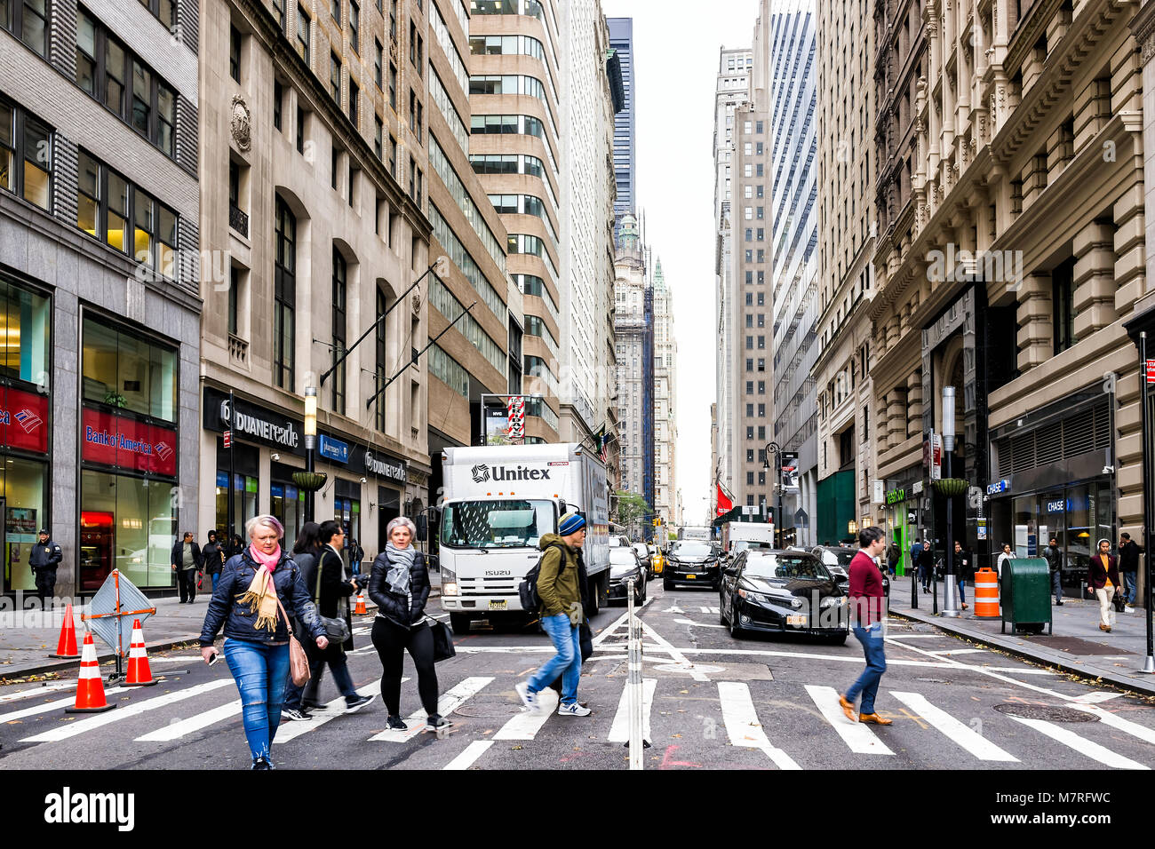 New York City, USA - 30. Oktober 2017: Broadway St von Wall Street Börse Charging Bull überschreitenden Personen in New York City Manhattan geringere finanzielle Distri Stockfoto