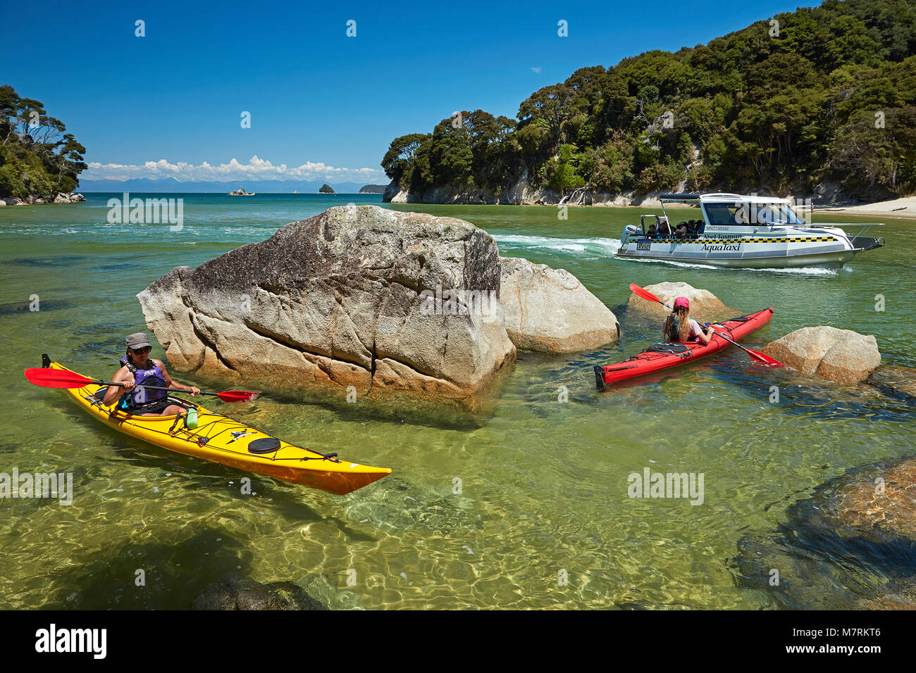 Kajakfahrer und Wassertaxi, Mosquito Bay, Abel Tasman National Park, Nelson, Südinsel, Neuseeland (Model Released) Stockfoto