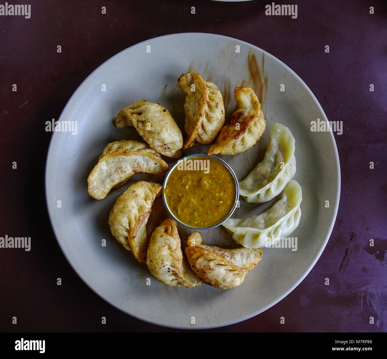Nepalesische traditionelle Knödel momos, serviert mit Sauce. Stockfoto