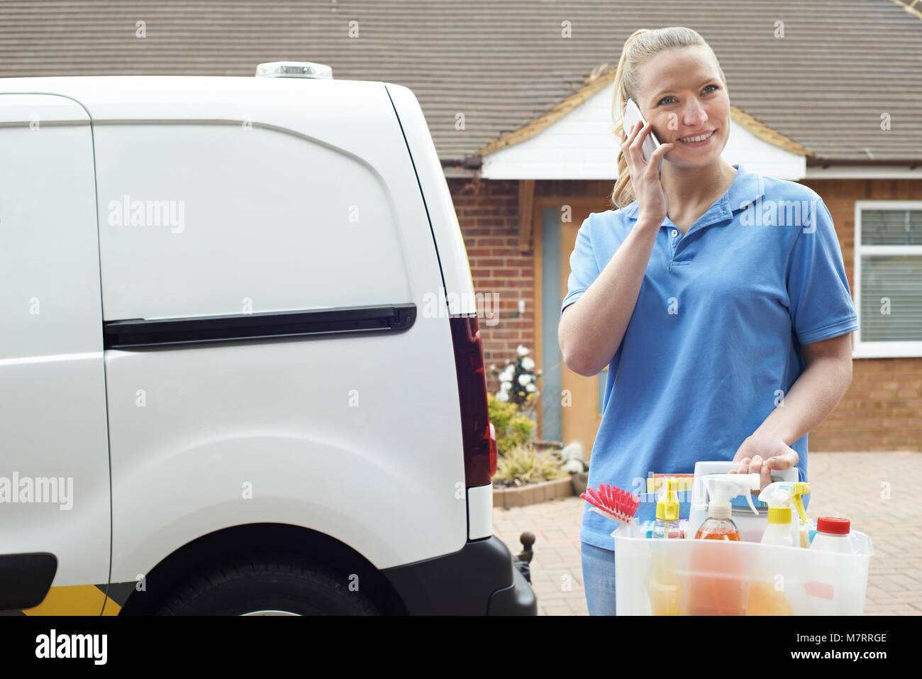 Junge Frau läuft Mobile Reinigung Geschäft mit Van mit Handy Stockfoto