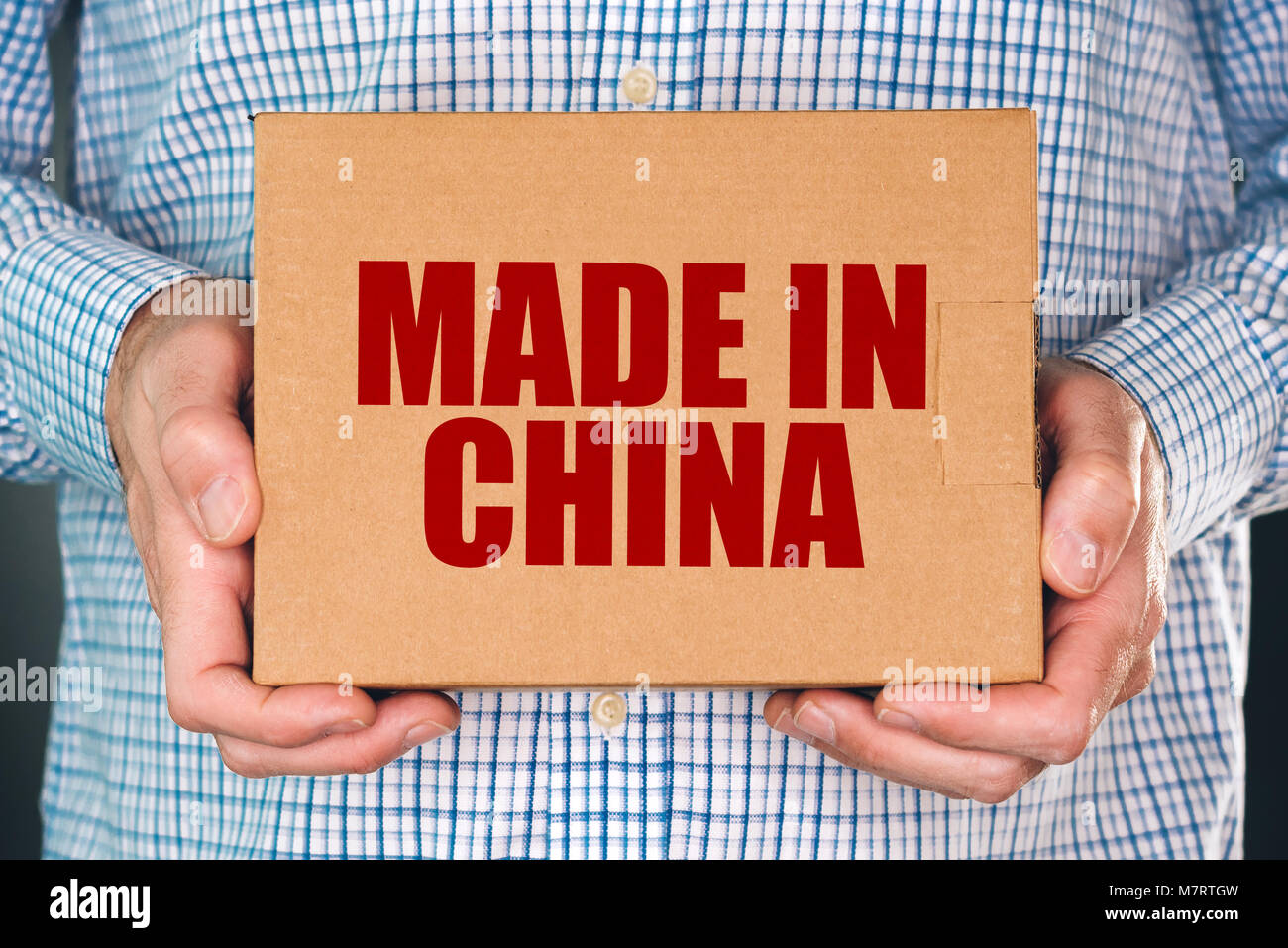 Mann mit Karton Produkt Paket mit Made in China label Impressum für Handelswaren aus Ostasien importiert Stockfoto