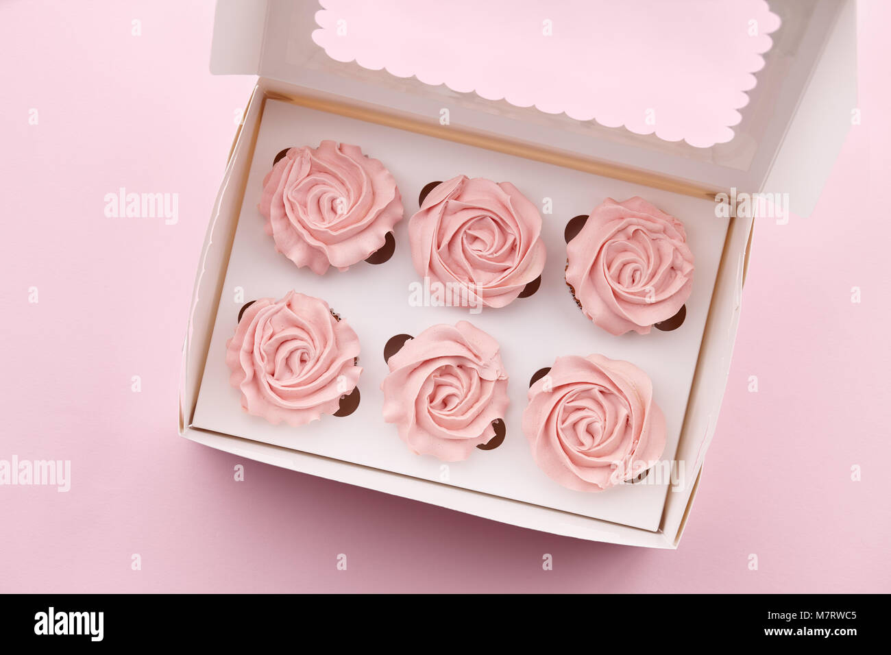 Muffins mit Blume geformte Creme in Feld Stockfoto