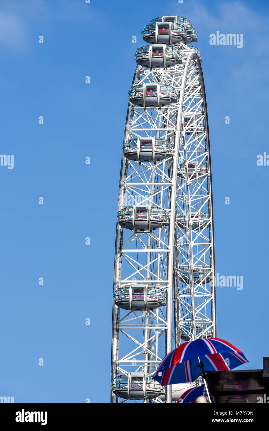 London Eye Millennium Wheel Coca Cola Riesenrad in London, Großbritannien. Mit dem Schirm der britischen Union Jack-Flagge auf dem Souvenirstand. Pods Stockfoto