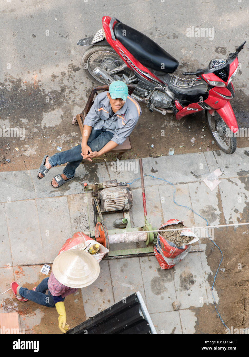 SAIGON, VIETNAM, Dec 15 2017, der Arbeiter dient eine Elektrowinde der Baustoff bis zu transportieren. Stockfoto