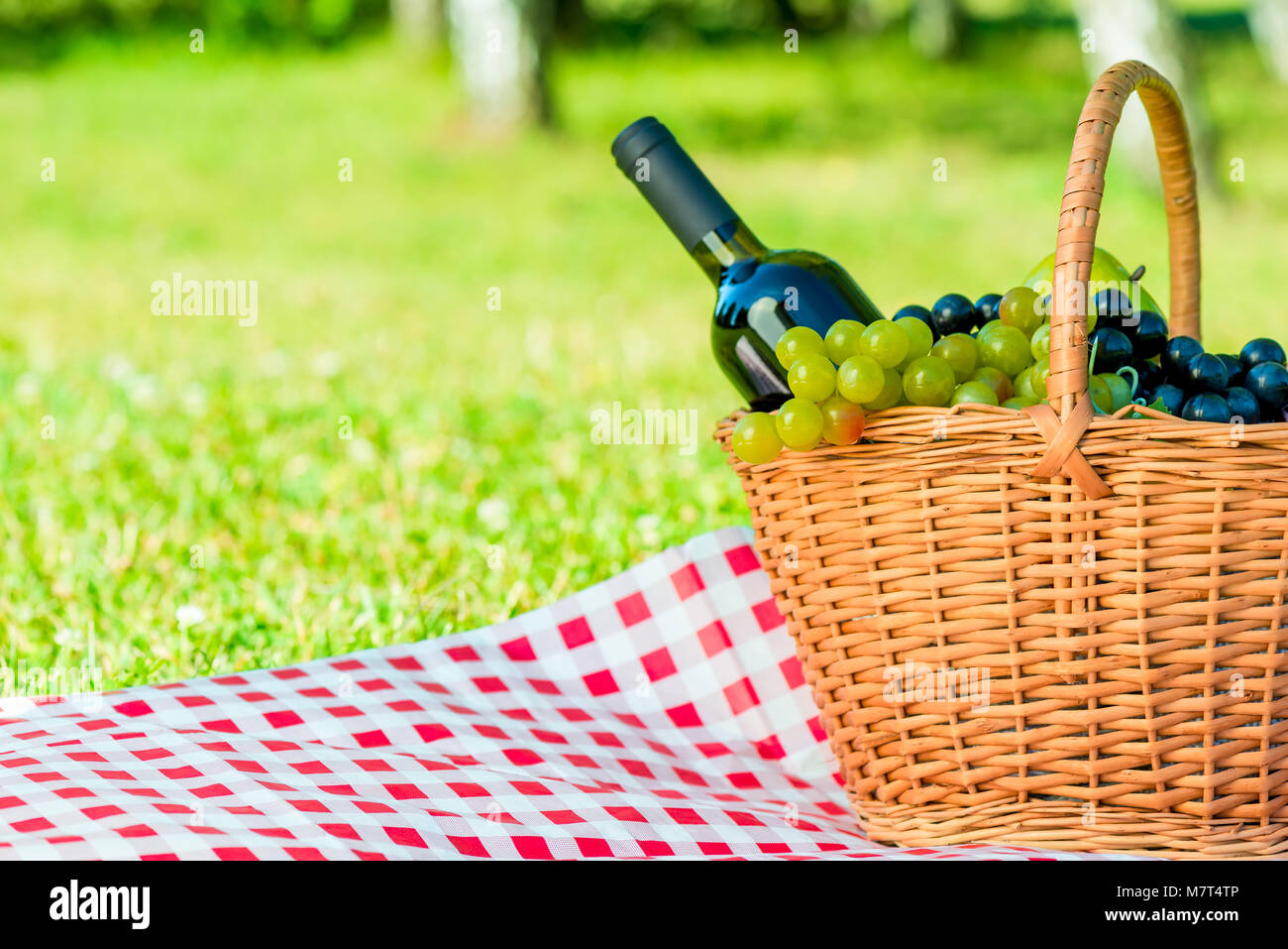 Korb mit Trauben und eine Flasche Wein und Raum zum Schreiben auf der linken Seite Stockfoto