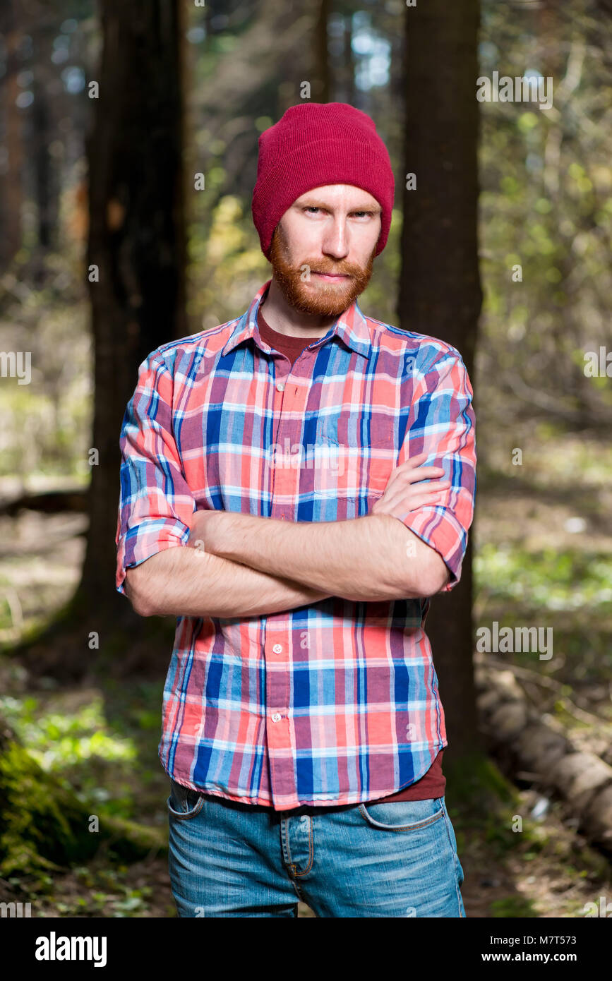 Porträt eines Mannes mit Bart in einem Plaid Shirt und Hut im Wald Stockfoto