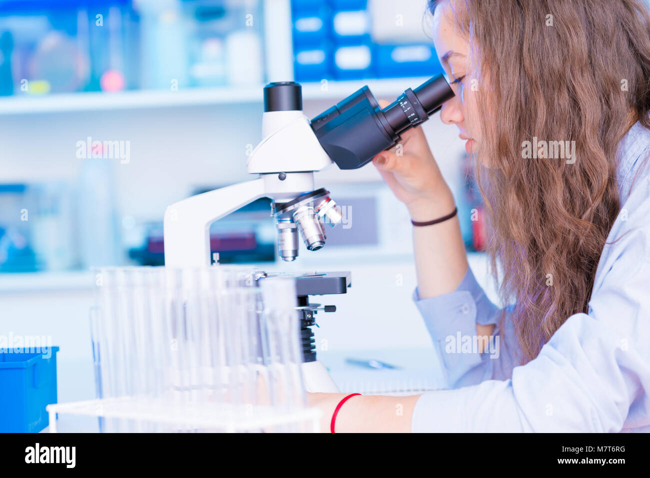 Schülerin Mädchen schaut durch ein Mikroskop zu einem Biologie Klasse auf ein Gymnasium Stockfoto
