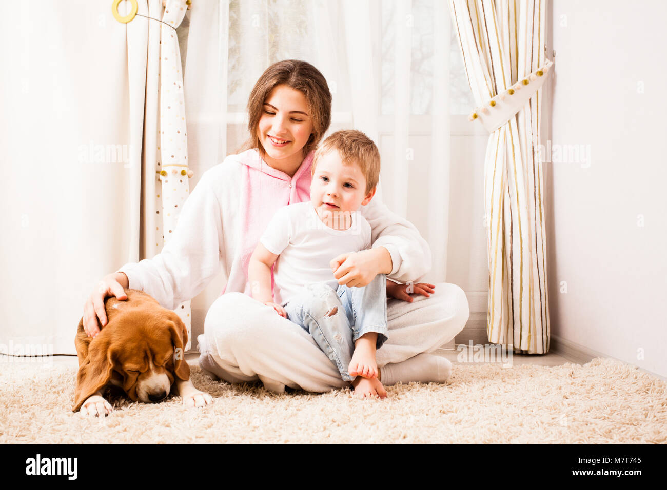 Der Junge, der mit seiner älteren Schwester und den Hund mit einem Rest Stockfoto