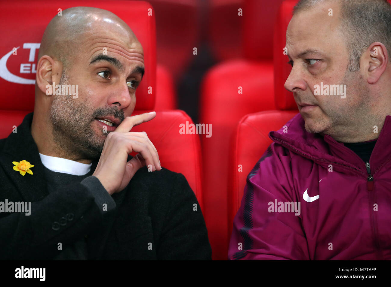 Manchester City Manager Pep Guardiola (links) mit einem gelben Blume auf der Jacke und Trainer Rodolfo Borrell vor dem Premier League Spiel in der bet365-Stadion, schüren. Stockfoto