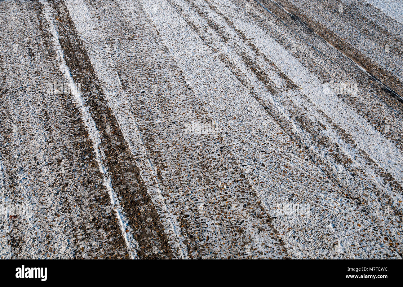 Abschnitt von einem eisigen Fahrbahn mit einem Abstauben des Schnees an einem kalten Februar morgen. Stockfoto