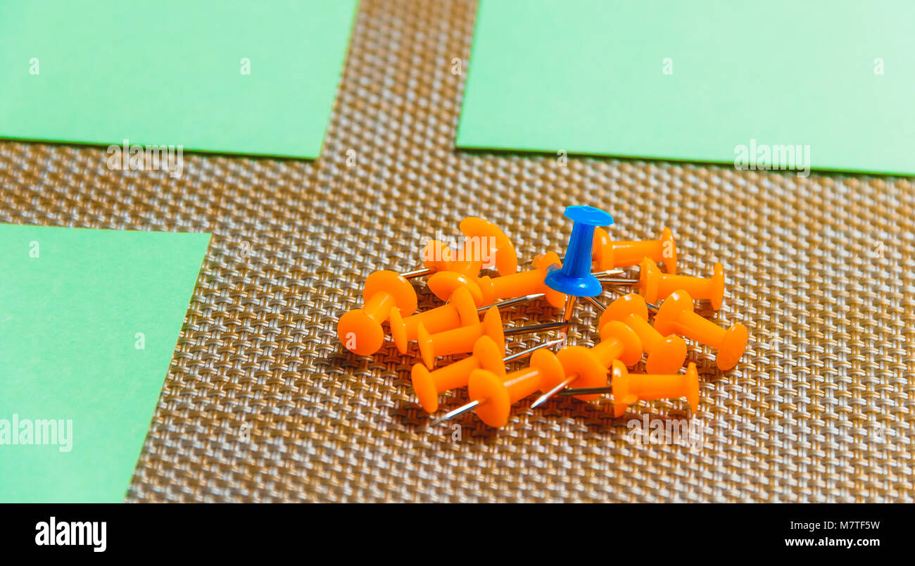 Stationäre, Orange, Blau Reißzwecken Heap auf braunem Hintergrund, Konzept für die Differenz, Individualität. Stockfoto
