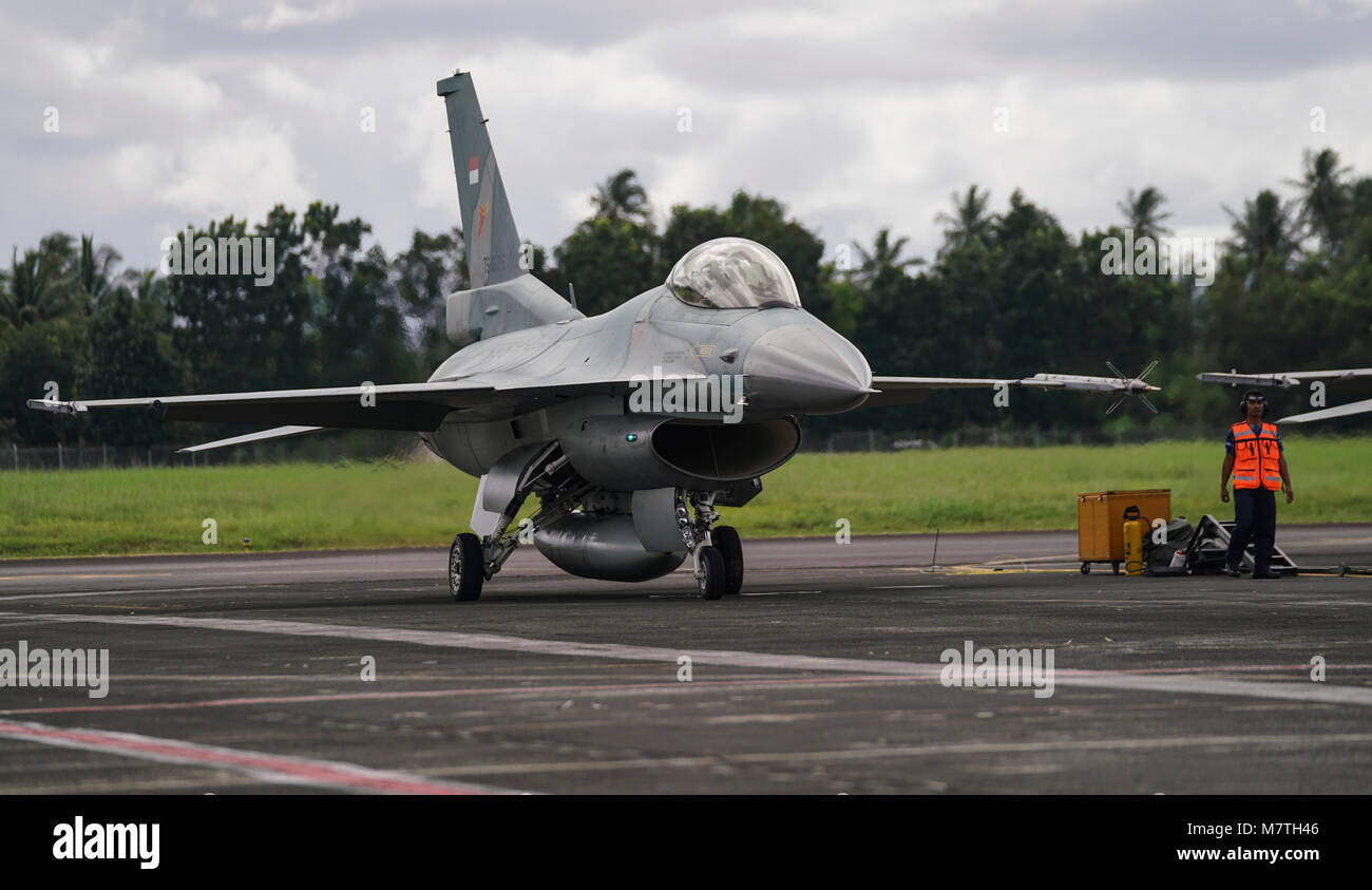 Ein indonesischer Air Force F-16 Fighting Falcon bereitet dem Start während der Übung bewältigen West 18 (CW18) von Sam Ratulangi International Airport, Indonesien, 12. März 2018. CW18 ist ein Pacific Air Forces - geförderte, bilaterale, taktische Kampfflugzeuge Übung für die USA und indonesischen Luftstreitkräfte und wurde entwickelt, um die Interoperabilität zu fördern und auf bereits etablierte Partnerschaften zwischen den Luftwaffen bauen. (U.S. Air Force Foto von Tech. Sgt. Richard Ebensberger) Stockfoto