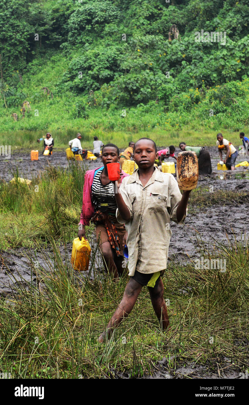 Kongolesische Dorfbewohner füllen ihre Wasserversorgung von diesem schlammigen Teich. Die einzige gute Quelle, die Sie haben. Stockfoto